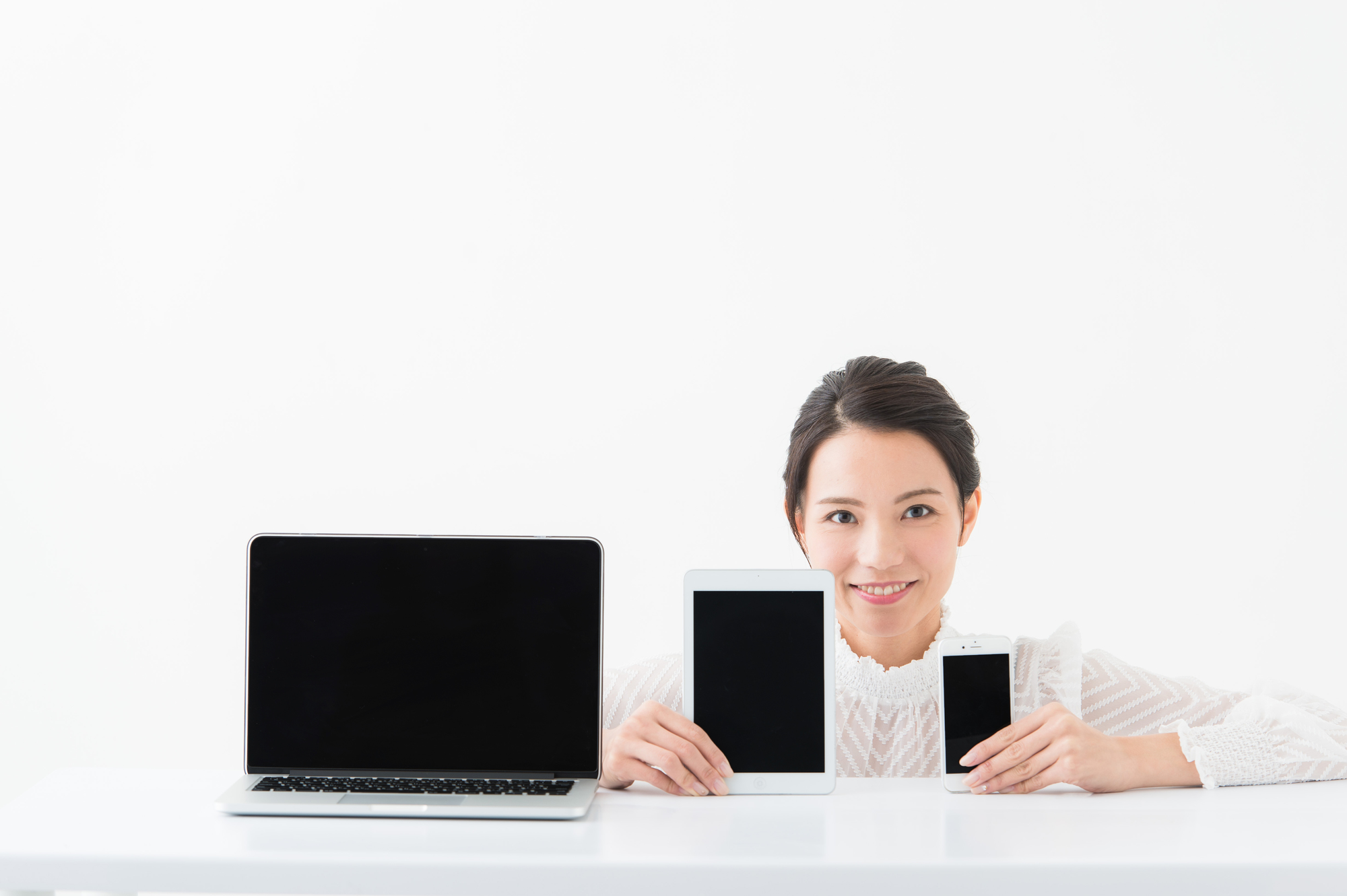 PC、スマートフォン、タブレットと微笑む女性のイメージ